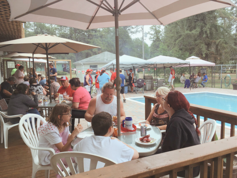 Families enjoying a barbecue deck side
