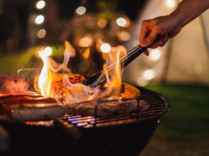 closeup of meat grilling with a night time lit background