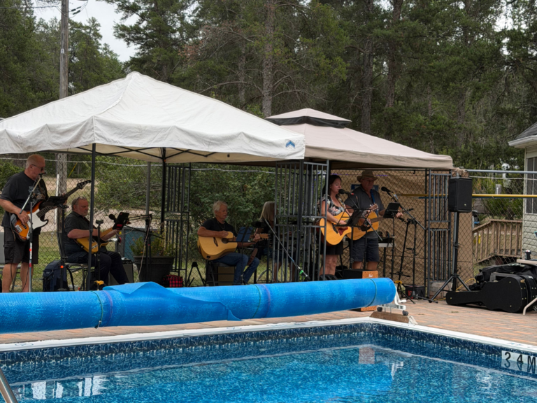Band playing poolside under canopies.